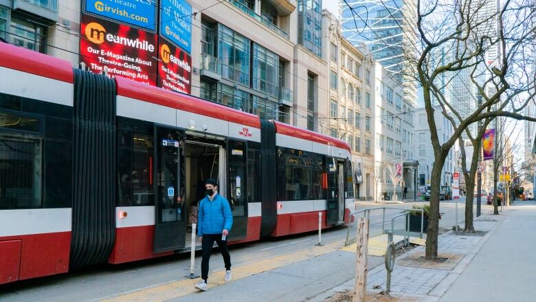 A man gets off a streetcar at the stop in front of the Princess of Wales Theatre in downtown Toronto on Thursday, March 4, 2021.