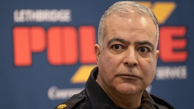 A close-up of a police official in his black uniform.