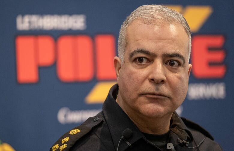 A close-up of a police official in his black uniform.