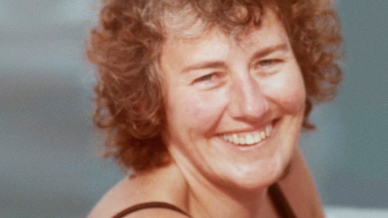 Smiling woman with curly short hair. 