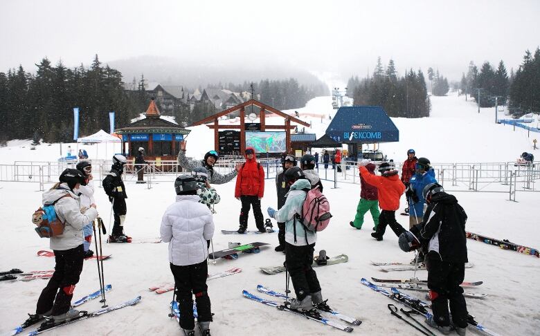 A group of skiers gather together at a ski resort.