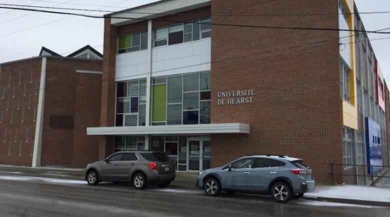 Picture of a building with a car parked in front.