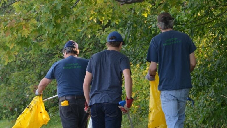 People carrying garbage bags pick up trash