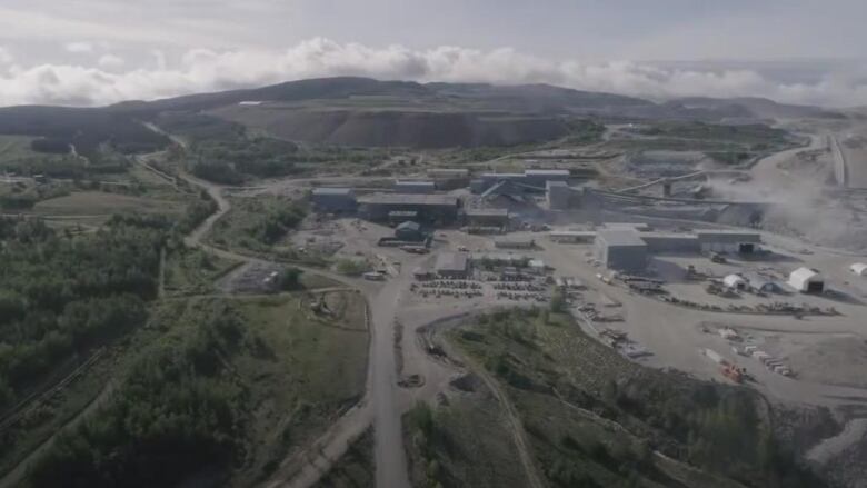 An aerial photo of a mine operation amid a hilly landscape.