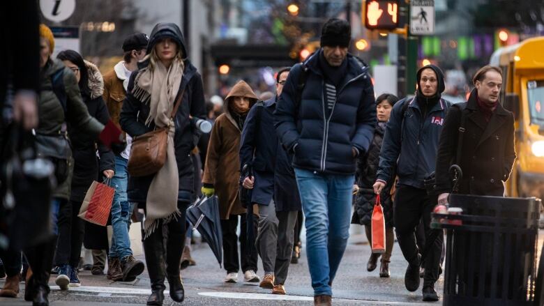 A group of people walk down a sidewalk in metro Vancouver.