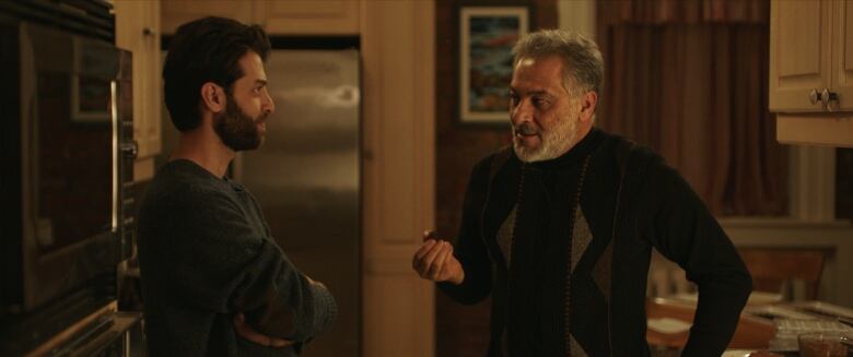 A still from the movie Peace by Chocolate showing two men (a father and his adult son) having a conversation in a kitchen.