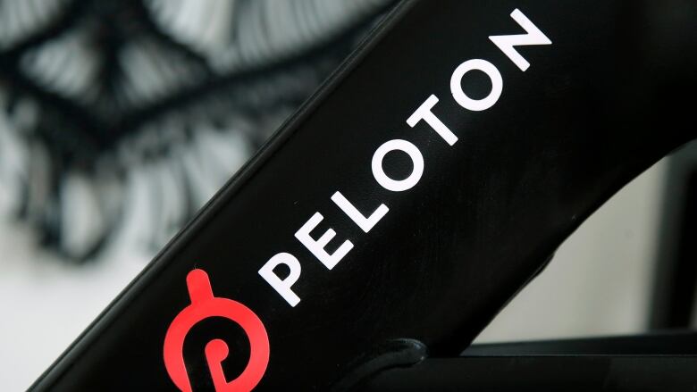 The Peloton logo is shown on a stationary bicycle.