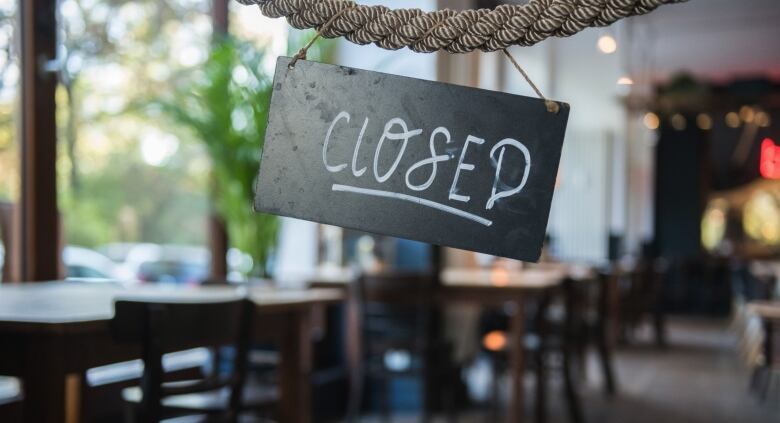 A closed sign hangs in a restaurant.