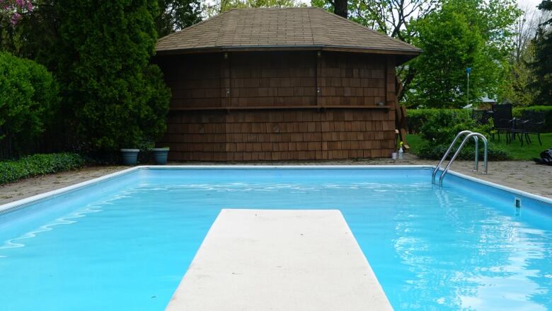 a backyard swimming pool with diving board