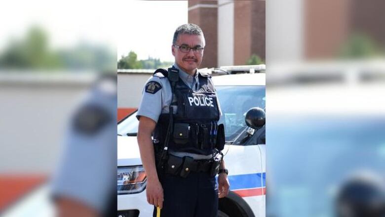 A vertical Image of Bernie Herman in his officer uniform with the borders blurred on both sides