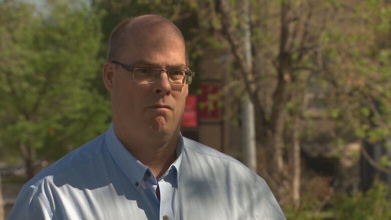 A man wearing a blue button-up shirt.