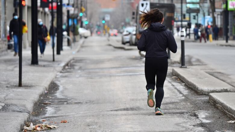 Woman running down a road.