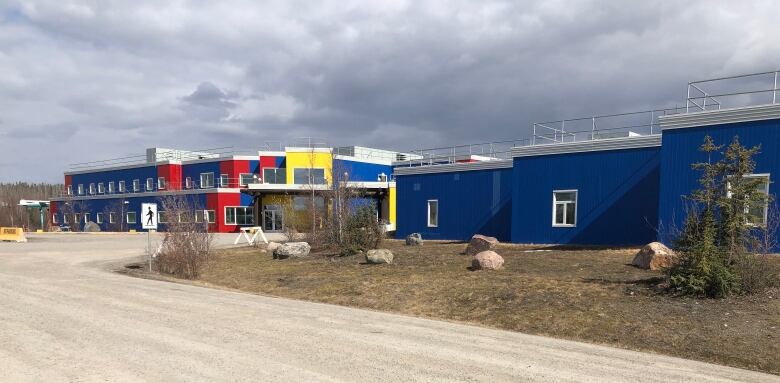 A long blue building with some yellow and red sections 