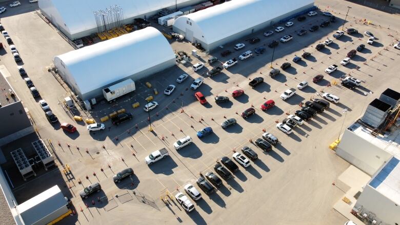 Vehicles line up at the drive-thru immunization clinic in Regina, Sask. 