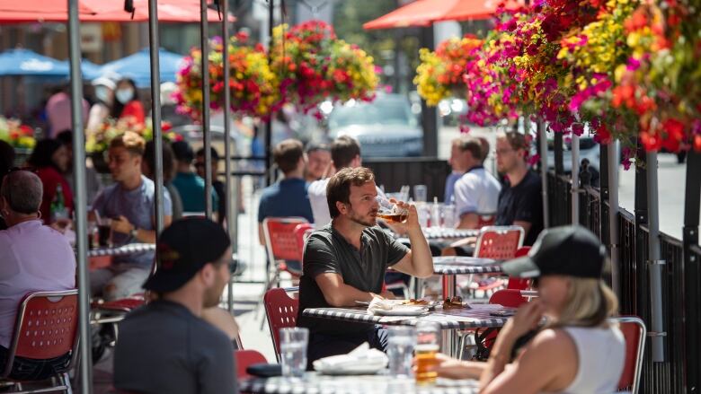 Man on a patio drinks a pint of beer