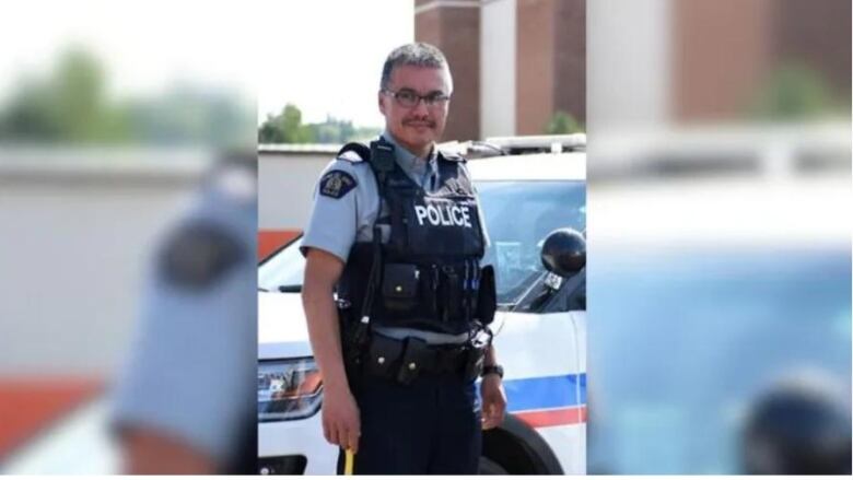 A man stands in a police uniform.