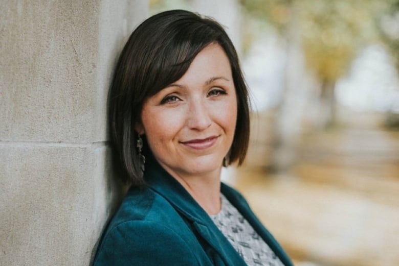 A woman with short, dark hair smiles 