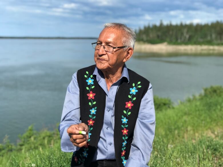 A portrait of a man by a river.