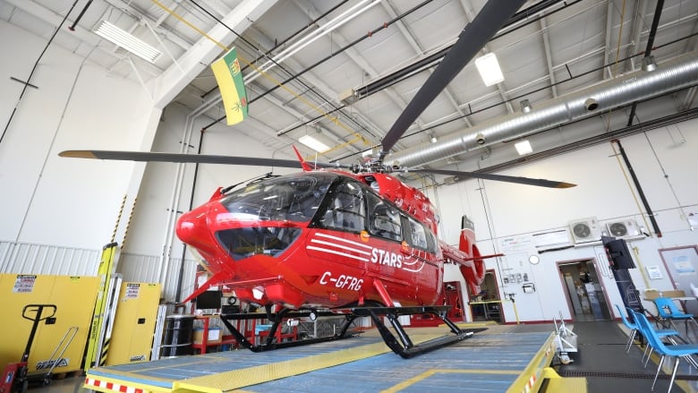 A red helicopter in a hanger.