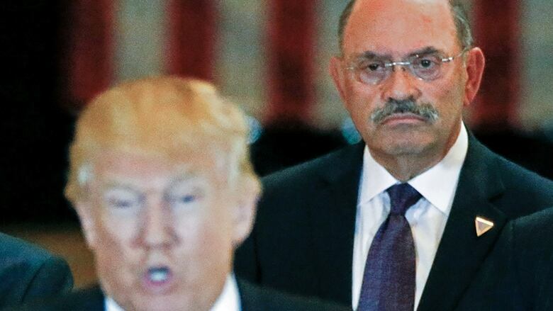 Donald Trump and the Trump Organization's chief financial officer, Allen Weisselberg, wear dark suits.