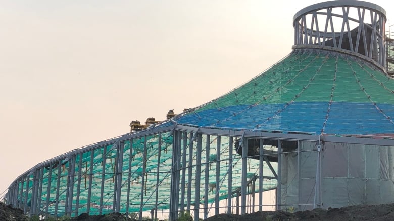 Blue and green covers atop roof panels of the Leaf building as it's under construction.