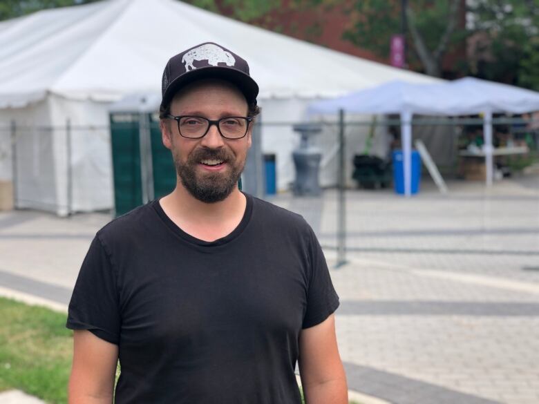 Zachary Atkinson stands outside wearing a black t-shirt.