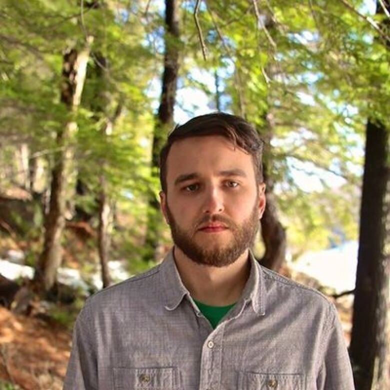 A man stands in a forest.