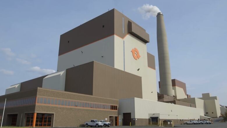 A brown and beige building with a single smokestack with the NB Power symbol on the front.