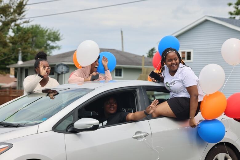 People hanging out of a car window