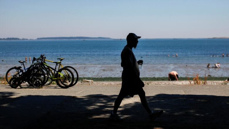 A man walks along Willows Beach during the 