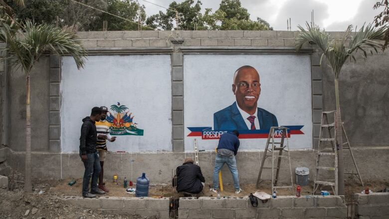 Artists paint a mural.