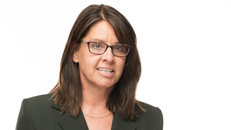 A woman in a blazer gesticulates.