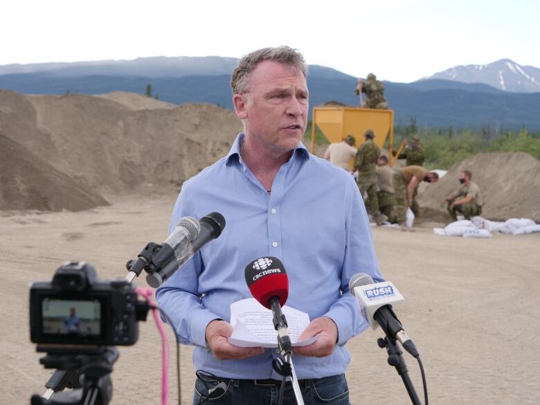 Man standing infront of Canadian militar personnel 