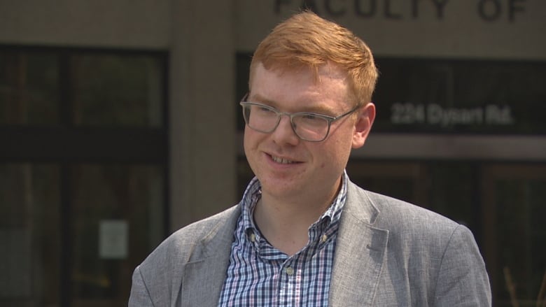 A man with glasses and red hair speaks.