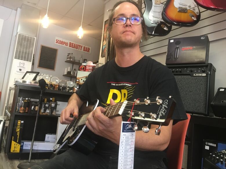 Phil Kikuchi sells coffee and guitars at his business Strings Cafe in London's Old East Village. He said a $40,000 government loan helped him continue operating during the pandemic, but is unsure how he can afford to pay it all back. He says he's weighing his options with banks.