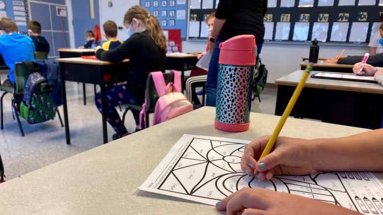 Students in class at Bloomfield Elementary School in PEI showing adaptations for public health protocols. See student at desk in fg working on a math sheet, shot from the side. Taken Aug 11, 2020.