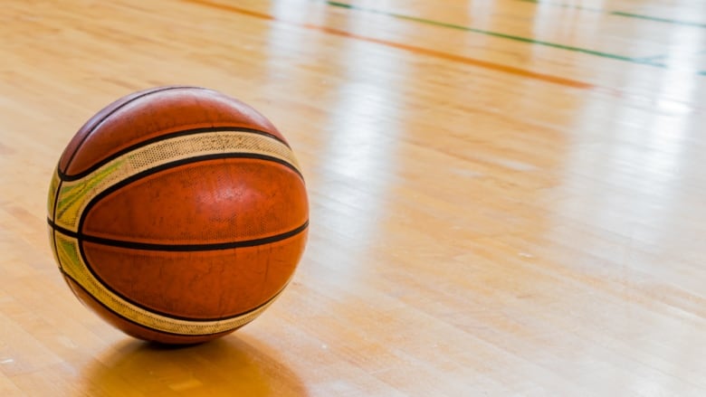 Basketball on gym floor.