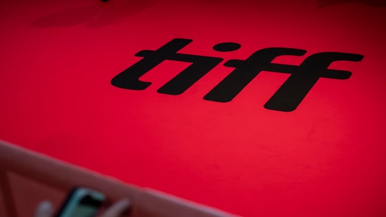 A red carpet bearing the word TIFF in bold black letters.