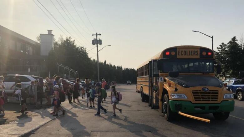 A bus with kids getting off of it