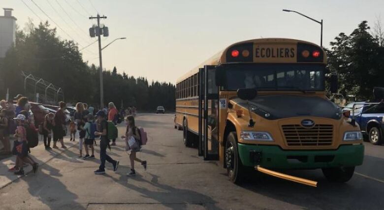 A bus with kids getting off of it