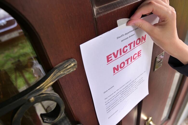 An eviction notice is pasted to a doorway.