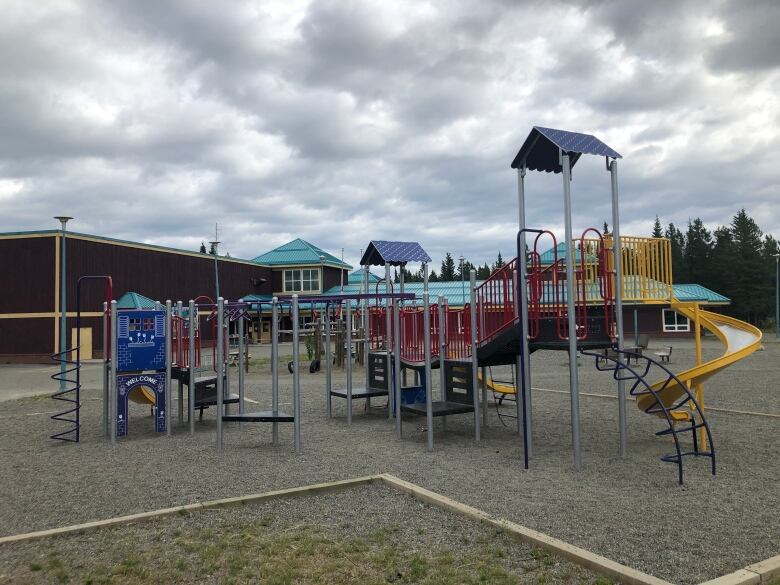 A large play structure is seen in a school playground.