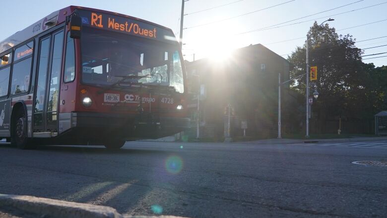 A red bus drives on a quiet street