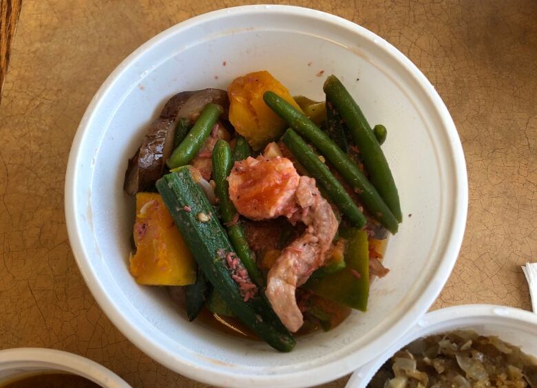 A bowl filled with shrimp, chunks of meat and vegetables.