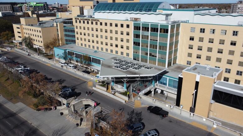 An aerial view of a large, tan building with many windows. It says 