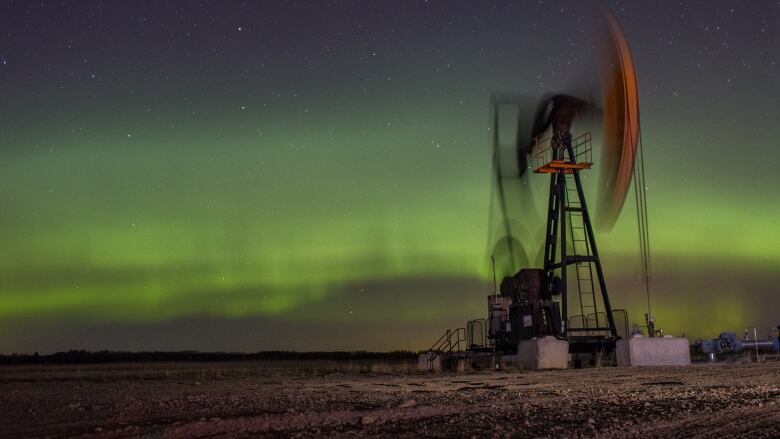 An oil pumpjack operates beneath the aurora borealis just north of Calgary.