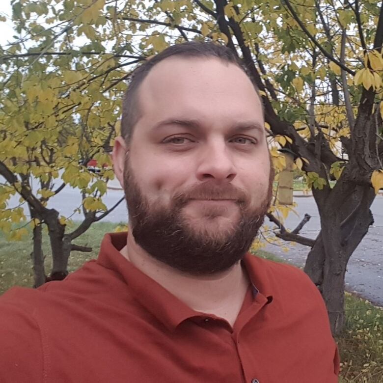 A profile photo of a man in a red shirt. 