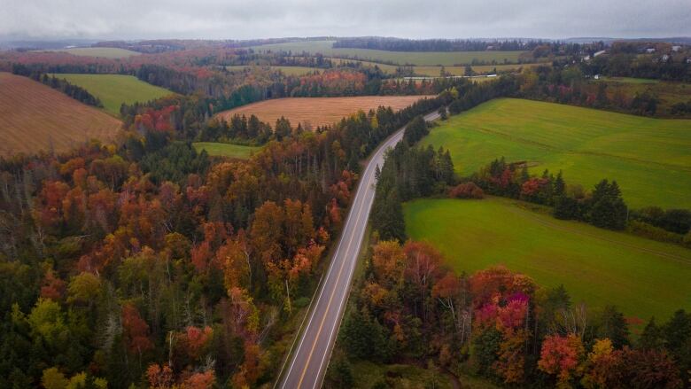 An aerial shot of a highway and fields in the fall.