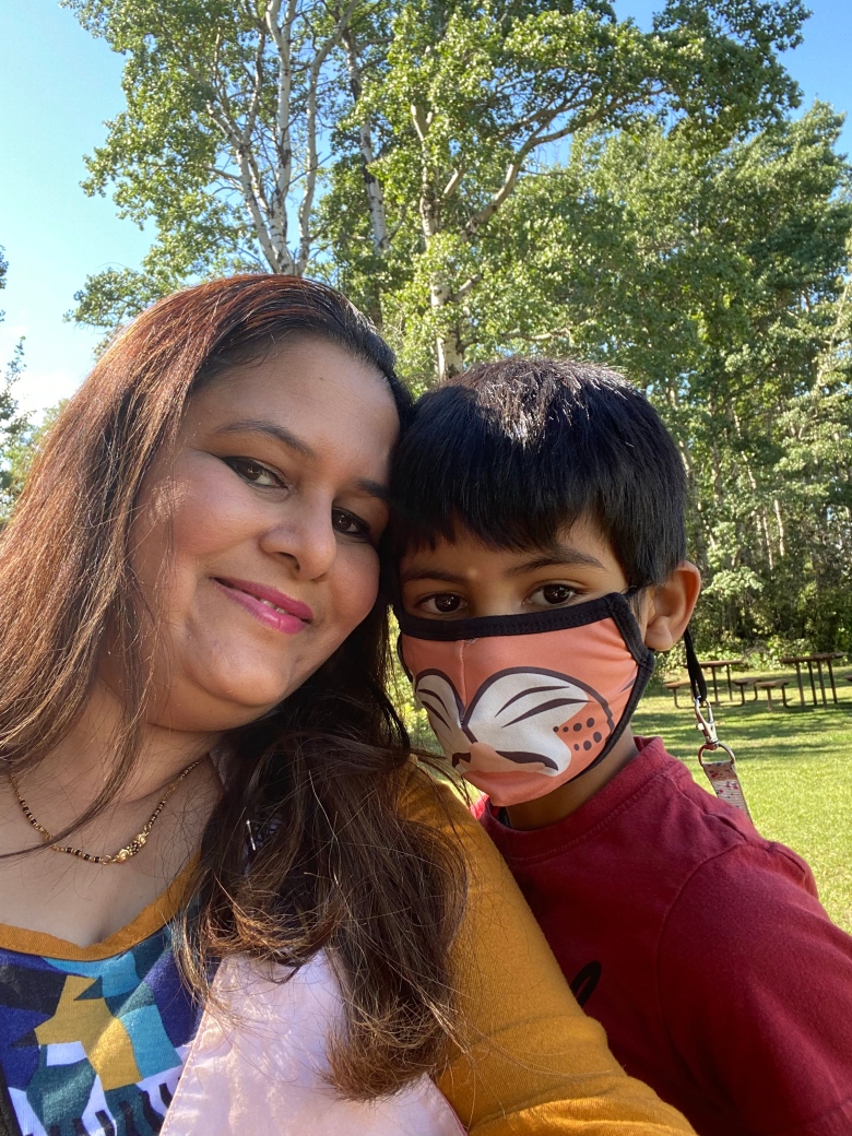 A woman smiles next to her child.