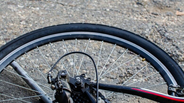 A bicycle tire is shown laying on a street.